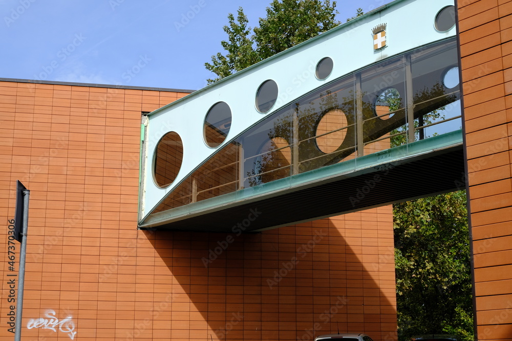 Wall mural modern pedestrian bridge. modern pedestrian bridge. walkway suspended between two buildings clad in 