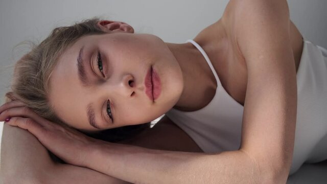 Face of sensual woman lying on floor over white background