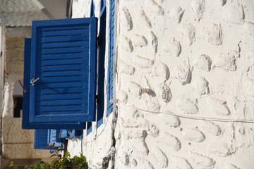 blue wooden windows and white textured wall