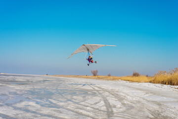 White sport hang glider on an ice field	