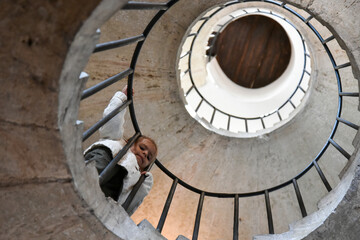 Bottom view of little girl standing on a spiral staircase - Specific learning disorders concept - Childhood difficulties concepts