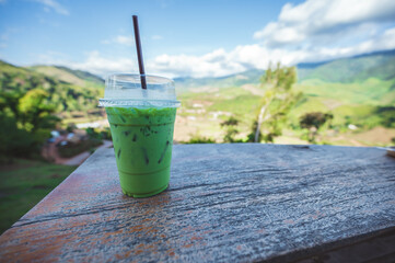 Close up green tea with mountain range view on the wooden balcony.