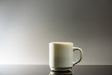 Black coffee in a white ceramic cup on a gray background a place for an inscription. Side view, top view. Selective focus