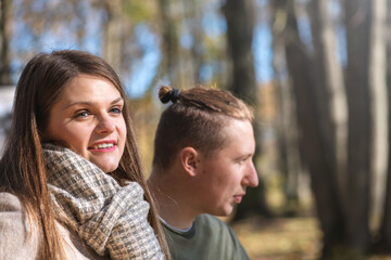 Relationship concept. Serious looking and thinking about something woman profile portrait with blurred man in background. Eye is in camera focus. Selective focus, image with shallow depth of field