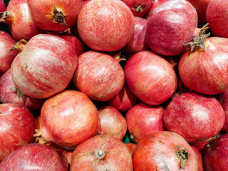 Red pomegranates in the market. Harvest concept. Organic fruits. Vegetarian food.