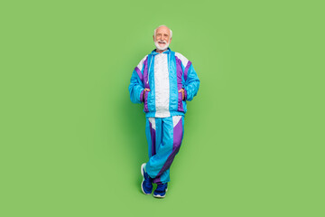 Fototapeta premium Photo of pretty attractive mature guy dressed blue sport suit smiling walking isolated green color background