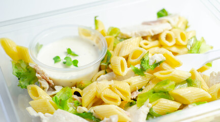 Penne pasta in a mayonnaise dressing with bacon pieces topped with parsley rubbed cooked chicken breast pieces
