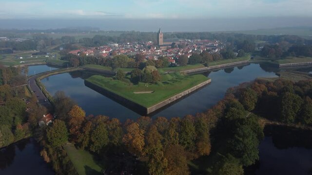 Fortress City Naarden Vesting in The Netherlands With Church and beautiful water reflections on a windless day, Aerial forwards downwards