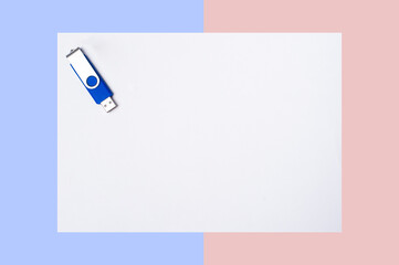Blue and silver USB stick isolated on a white background with light pink and blue enges.