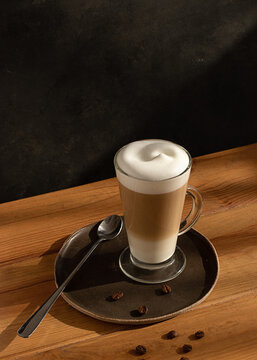 Glass cup of hot latte in cafe table