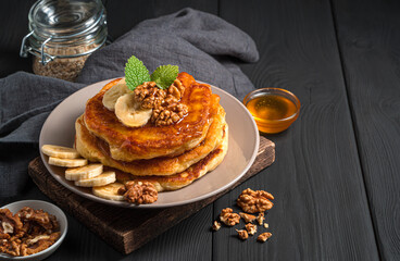 A stack of homemade pancakes on a black background.