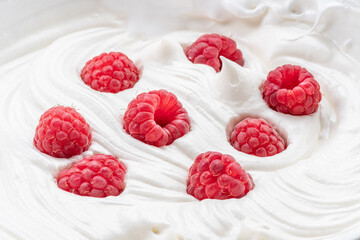 Fresh raspberries in the yoghurt or cream. Top view.