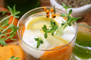 Dessert with yogurt, persimmon and hemp sativa sprouts on wooden background