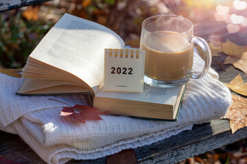 Calendar for 2022 on the background of an autumn day. Coffee, book, pumpkins, halloween.