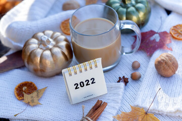 Calendar for 2022 on the background of an autumn day. Coffee, book, pumpkins, halloween.