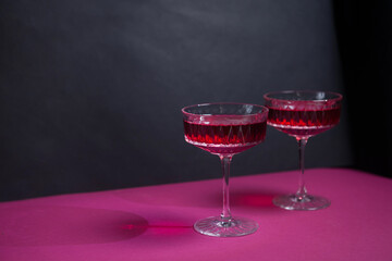 Two red wine glasses on a black background with copy space for your text.tempting offer advertising red wine. wine list. restaurant advertising. a bright combination of red and black. romantic dinner