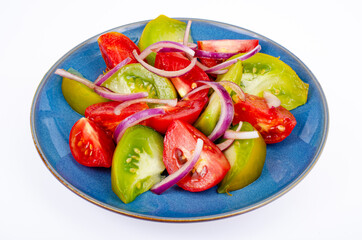 Plate with slices of ripe tomatoes of different colors. Studio Photo.