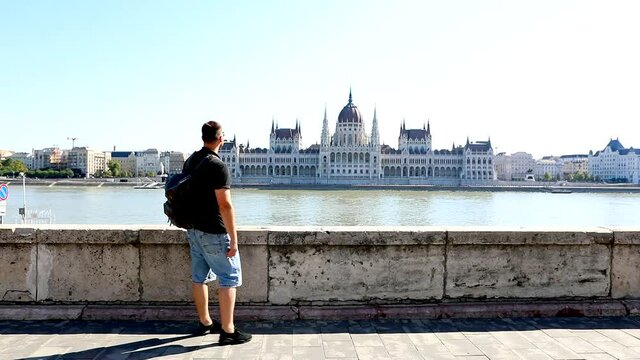 man traveler taking picture of budapest parliament building