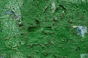 Peeling paint on the wall. Old wall with cracked flaking paint. Weathered rough painted surface with patterns of cracks and peeling. Grunge texture for background and design.