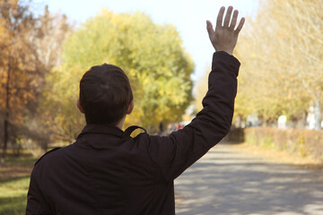 Back view guy student stretches out his right hand for greeting 