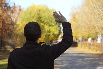 Back view guy student stretches out his right hand for greeting 