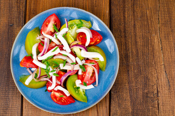 Healthy vegetable salad with tomatoes and squid pieces. Studio Photo.