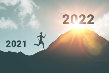 Silhouette of active man running and sprint uphill with new year 2022 concept