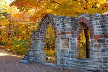 Walls of abbey ruins in autumn with yellow and orange leaves. Mackenzie King Estate, Gatineau Park, Quebec, Canada.