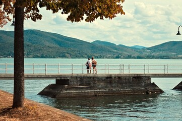 A family on the pier of the Trasimeno Lake in a summer day (Umbria, Italy, Europe) - 467402114