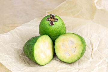 Fresh green feijoa (pineapple guava) fruit slices on light background in the kitchen.