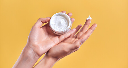 Skin care product. Close-up of women's hands holding a face cream jar. Beauty and spa product.