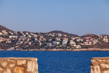 Cukurbag peninsula with a large number of hotels and houses on a mountainous surface in the mediterranean sea in kas region, turkey.
