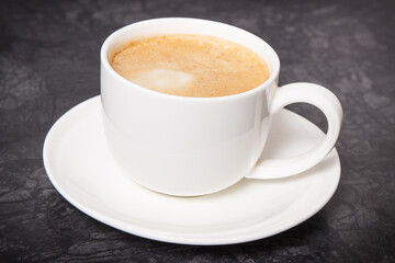 Cup of coffee with milk on dark background