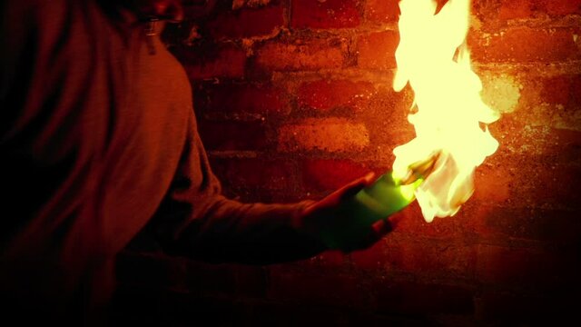 Anonymous Man Throws Molotov Cocktails By Brick Wall