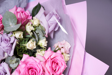A large colorful bouquet of flowers. Large pink roses and eucalyptus leaves. On a light background, side view. The concept of the holiday. High quality photo