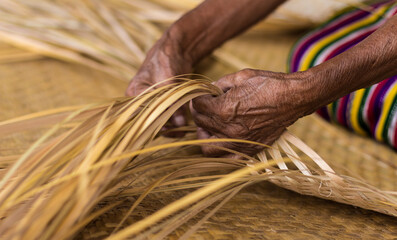 Kiche woman braiding palm fiber