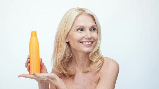 Cheerful lady presenting hair conditioner bottle special sale proposition