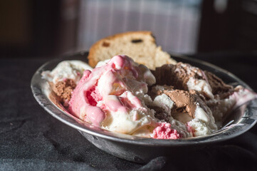 Panettone with various ice creams in a metal bowl ,copy space