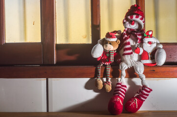 Christmas, concept with teddy bears sitting in a window and hugging each other, copy space left
