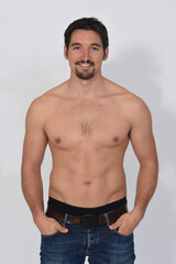 Fototapeta premium portriat of a man shirtless smiling and hands on pocket on white background