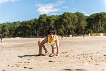 little caucasian girl playing on the beach