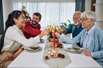 Fototapeta na wymiar Family toasting at christmas dinner in the dinning room