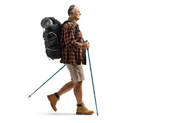 Full length profile shot of a mature hiker with a backpack walking with trekking poles