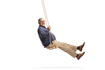 Full length side shot of a happy mature man swinging on a swing