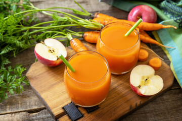 Fresh natural juice, healthy food concept. Glass jar of fresh apple and carrot juice on a wooden rustic table.