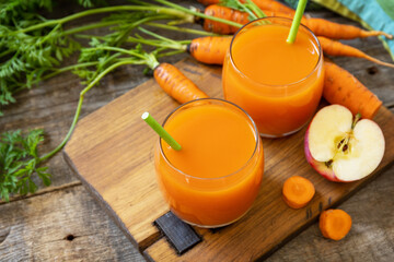 Fresh natural juice, healthy food concept. Glass jar of fresh apple and carrot juice on a wooden rustic table. Copy space.