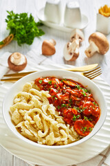 spaetzle with mushroom gravy in a white bowl