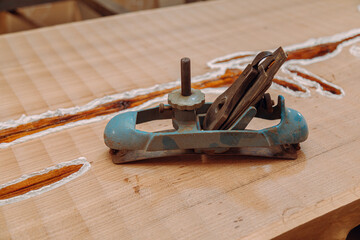 Old metallic jointer plane laying on wood table