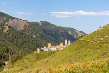 Panoramic view on Adishi,a mountain village,located in the High Caucasus,Svaneti Region in Georgia.The Svan watch towers are behind the lush green hills,where cows are grazing. Hiking trail,Solitude.