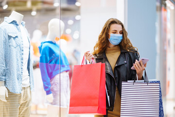 Stylish woman in protective mask after shopping. Black friday. Consumerism, purchases, sale, lifestyle, tourism concept.